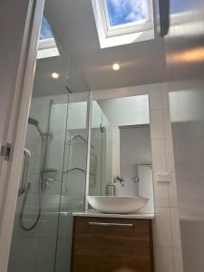 La salle de bains est pourvue d'un lavabo et d'une douche. dans l'établissement Aspiring View Apartments, à Wanaka