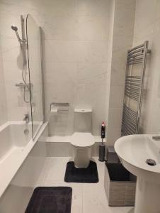 a white bathroom with a toilet and a sink at 2 bedroom en-suite apartment in Basildon, Essex (Enjoy the simple things in life) in Laindon