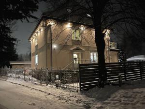 a house with a fence in the snow at night at Villa Śnieżka in Kowary
