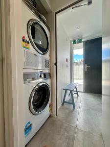 a laundry room with a washer and dryer next to a door at Aspiring View Apartments in Wanaka