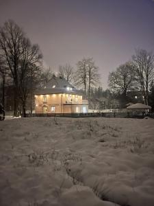 een huis in een veld bedekt met sneeuw bij Villa Śnieżka in Kowary