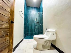 a bathroom with a toilet and a shower at Selva Pacific Mountain Beach retreat in Quebrada Ganado