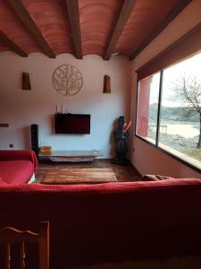 a living room with a couch and a large window at Casa Rural Miravella in Castril