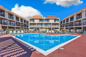 una piscina frente a un gran edificio de apartamentos en Gulfside Townhomes 23, en Gulf Shores