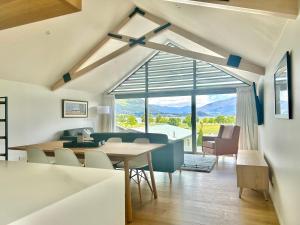 Una sala de estar con una mesa y sillas y una gran ventana. en Aspiring View Apartments, en Wanaka