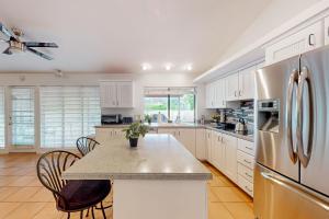 a kitchen with white cabinets and a table with chairs at Cactus Cove in Scottsdale