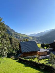 un fienile in un campo con montagne sullo sfondo di La Tanière de Sven - Vue Montagne a Saint-Nicolas-la-Chapelle Altre 32 foto