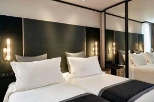 duas camas num quarto de hotel com almofadas brancas em Academias Hotel, Autograph Collection em Atenas