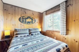 - une chambre avec un lit et un mur en bois dans l'établissement Lakefront Lookouts 1 & 2, à Lakeside