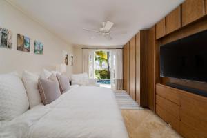 a living room with a white couch and a flat screen tv at Royal Westmoreland - Sugar Cane Ridge 3 townhouse in Saint James