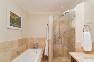 ein Badezimmer mit Badewanne, Dusche und Waschbecken in der Unterkunft Royal Westmoreland - Sugar Cane Ridge 3 townhouse in Saint James + 6 Fotos