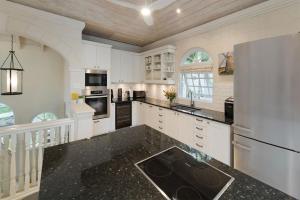 a kitchen with white cabinets and a black counter top at Royal Westmoreland - Sugar Cane Ridge 3 townhouse in Saint James