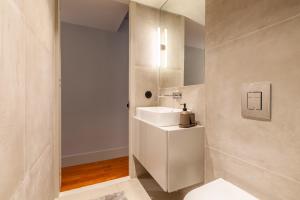 Un baño blanco con lavabo y espejo. en Sta. Catarina 618 Suite, en Oporto 18 fotos más