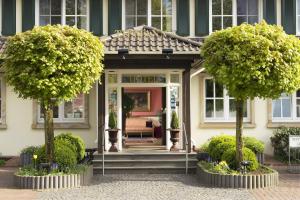 una casa con dos árboles delante de ella en Tiemann's Hotel, en Stemshorn