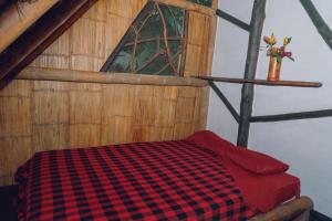 a bedroom with a checkered bed in an attic at Magia Verde Lodge in Puerto Misahuallí