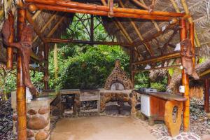 an outdoor kitchen with a grill in a hut at Magia Verde Lodge in Puerto Misahuallí