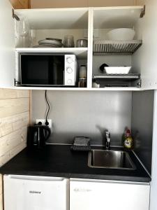 a kitchen with a sink and a microwave at REY Stays - Small & Cozy Studio in Höfn