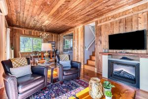 a living room with a fireplace and a flat screen tv at Ferry Viewer Cottage in Point Roberts