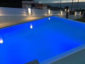 a blue swimming pool with lights on a roof at Doniños Nature in A Coruña
