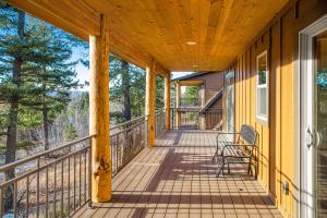 un porche de madera con mecedora en Experience Montana - Dream Catcher Luxury Cabin #8, en Bigfork
