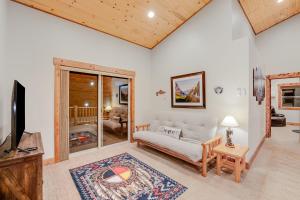 sala de estar con sofá blanco y TV en Experience Montana - Dream Catcher Luxury Cabin #8, en Bigfork