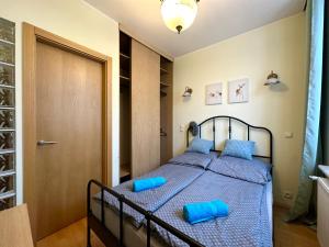 a bedroom with a bed with blue pillows on it at Apartament z widokiem na stary rynek in Wejherowo