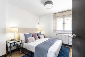 - une chambre avec un grand lit et une fenêtre dans l'établissement Luxury duplex close to Gran Via Colon, à Madrid