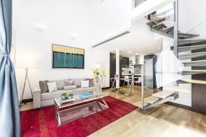 salon z kanapą i schodami w obiekcie Cibeles by SkyKey w Madrycie +28 zdjęć
