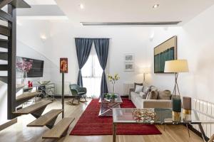 een woonkamer met een bank en een tafel bij Luxury duplex close to Gran Via Colon in Madrid