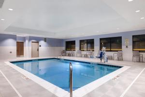 a pool in a hotel with chairs and tables at Hampton Inn Chicago Orland Park in Orland Park