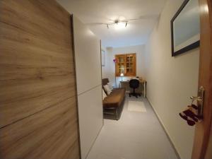 a room with a sliding door with a couch and a desk at Apartamentos Bon Amb in Faro de Cullera
