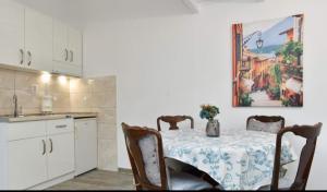 a kitchen with a table with chairs and a painting on the wall at Budva OLD TOWN 4 apartment in Budva