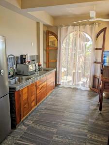 a kitchen with a sink and a refrigerator at Suites La Hacienda in Puerto Escondido