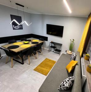 un soggiorno con un tavolo e un divano di Apartament Na Wspólnej a Sosnowiec
