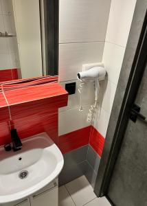 a bathroom with a sink and a blow dryer at Apartament Na Wspólnej in Sosnowiec