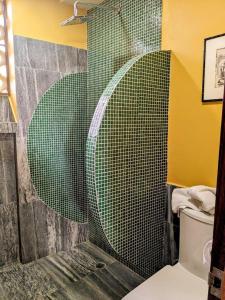 a bathroom with a shower with a green tiled wall at Suites La Hacienda in Puerto Escondido