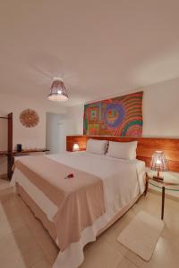 1 dormitorio con 1 cama grande y una pintura en la pared en Pousada Rota Ecológica, en Porto de Pedras