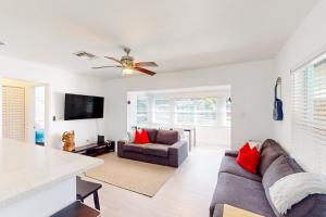 een woonkamer met een bank en een tv bij Palm Shadow Sanctuary in Fort Lauderdale