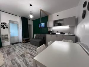 a kitchen and living room with a white table and chairs at Casa Basarab Brasov in Braşov