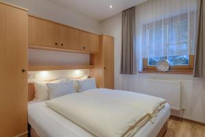 a bedroom with a large white bed and a window at Pension St. Florian in Sankt Johann im Pongau