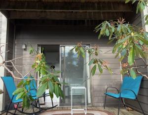 Duas cadeiras azuis e uma mesa no alpendre. em Cozy Condo in Wintergreen Resort That Sleeps 4! em Lyndhurst
