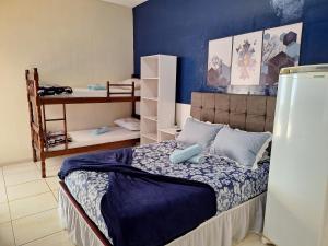 een slaapkamer met een bed met een blauwe muur bij Pousada JOSHUA in Penha