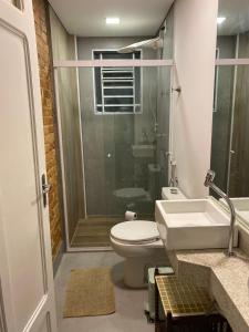 a bathroom with a toilet and a sink and a shower at Casa Ipê Baobá in São Paulo