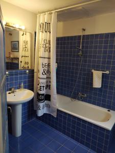 a blue tiled bathroom with a tub and a sink at Can Penjarella II in Arbúcies