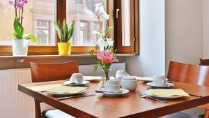 a wooden table with a vase of flowers on it at Hotel Restaurant Krokodil in Heidelberg