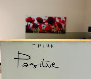 a sign that says think positive in front of a painting at E2G URBAN STAY #G1 in Thessaloniki