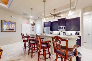 a kitchen with wooden chairs and a bar with a counter at Palm & Friends Estate in Cape Coral