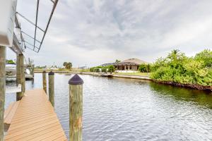 a dock on a river with a house in the background at Palm & Friends Estate in Cape Coral