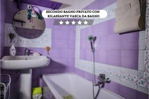 baño púrpura con lavabo y bañera en Storico con parcheggio gratuito in pieno centro, en Santa Maria Capua Vetere