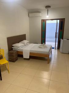 1 dormitorio con 1 cama y 1 silla amarilla en Pousada Belas Praias en São José da Coroa Grande